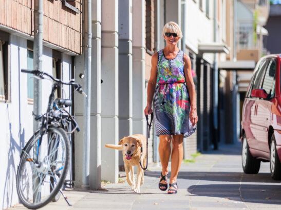Woman Walking Dog in City